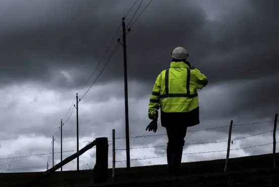 Image d'un technicien travaillant sur une ligne électrique endommagée après une tempête